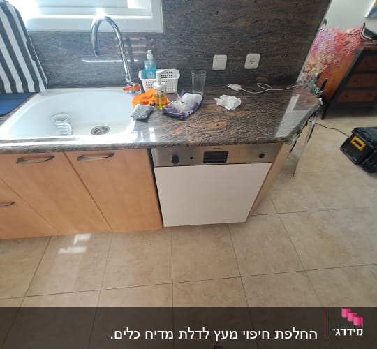 כיור מטבח עם כלים וסבון על השיש